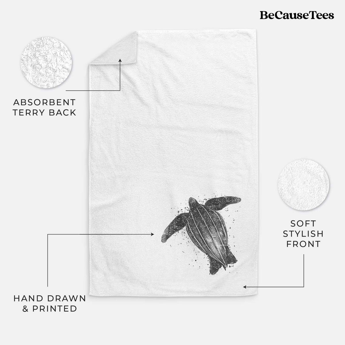 White hand towel printed with a black ink illustration of a leatherback sea turtle swimming, with ink splatters.