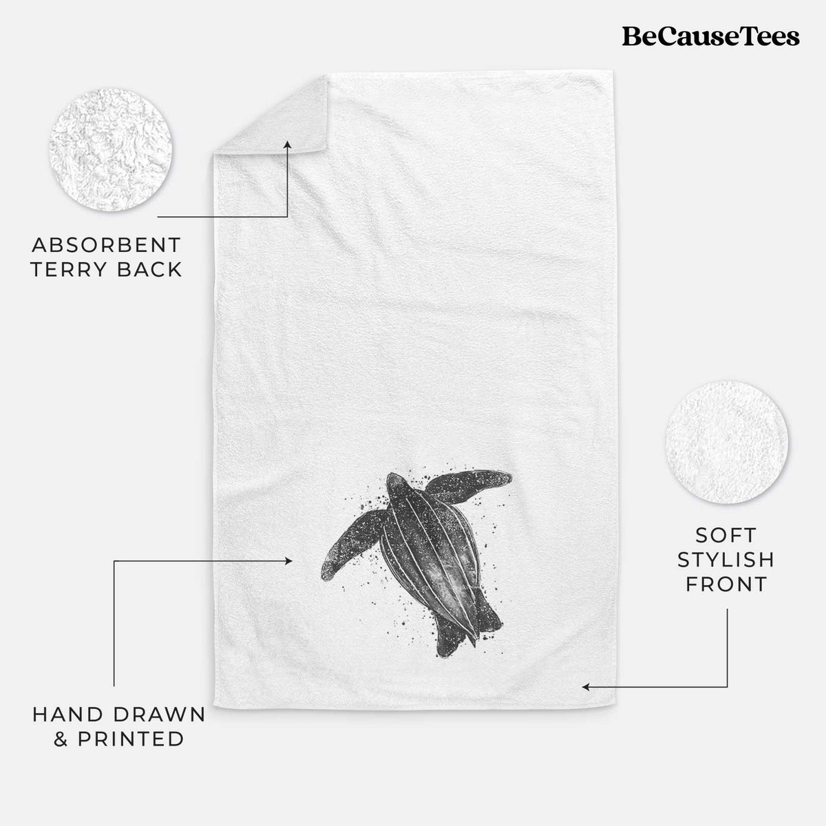 White hand towel printed with a black ink illustration of a leatherback sea turtle swimming, with ink splatters.