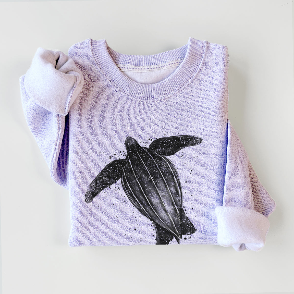 Ice purple knit sweatshirt printed with a black ink illustration of a leatherback sea turtle swimming, with ink splatters, styled flat.