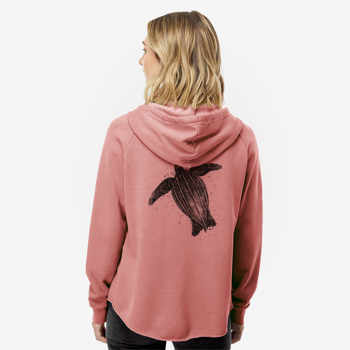 Woman wearing a dusty rose women's Cali Wave zip-up sweatshirt printed with a black ink illustration of a leatherback sea turtle swimming, with ink splatters, seen from behind.