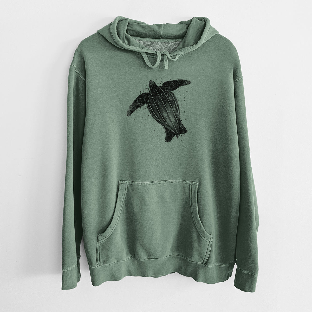 Alpine green pigment dyed hoodie laid flat, printed with a black ink illustration of a leatherback sea turtle swimming, with ink splatters.
