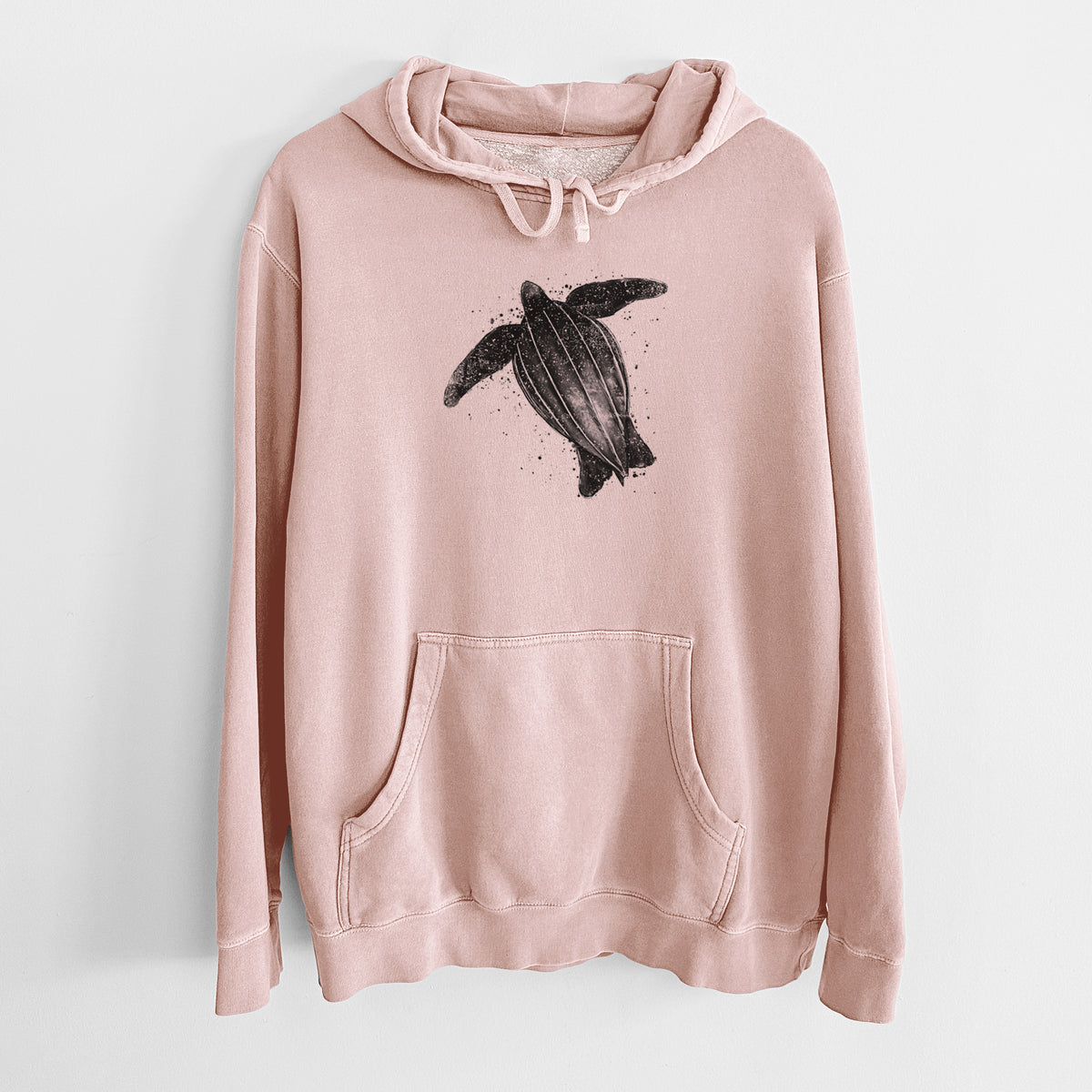 Dusty pink pigment dyed hoodie laid flat, printed with a black ink illustration of a leatherback sea turtle swimming, with ink splatters.