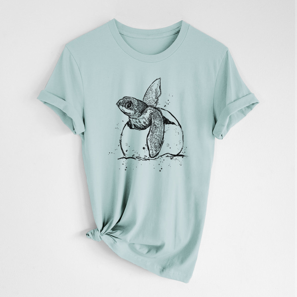Dusty blue lightweight cotton t-shirt laid flat with the sleeves rolled, printed with a black ink illustration of a leatherback sea turtle hatchling emerging from its egg.