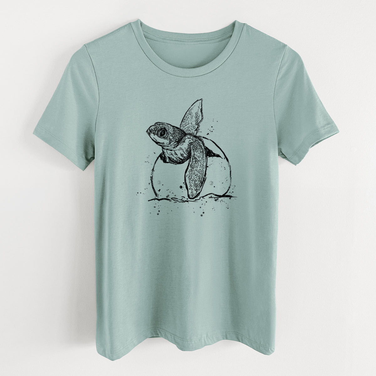 Dusty blue women's relaxed fit cotton t-shirt laid flat, printed with a black ink illustration of a leatherback sea turtle hatchling emerging from its egg.
