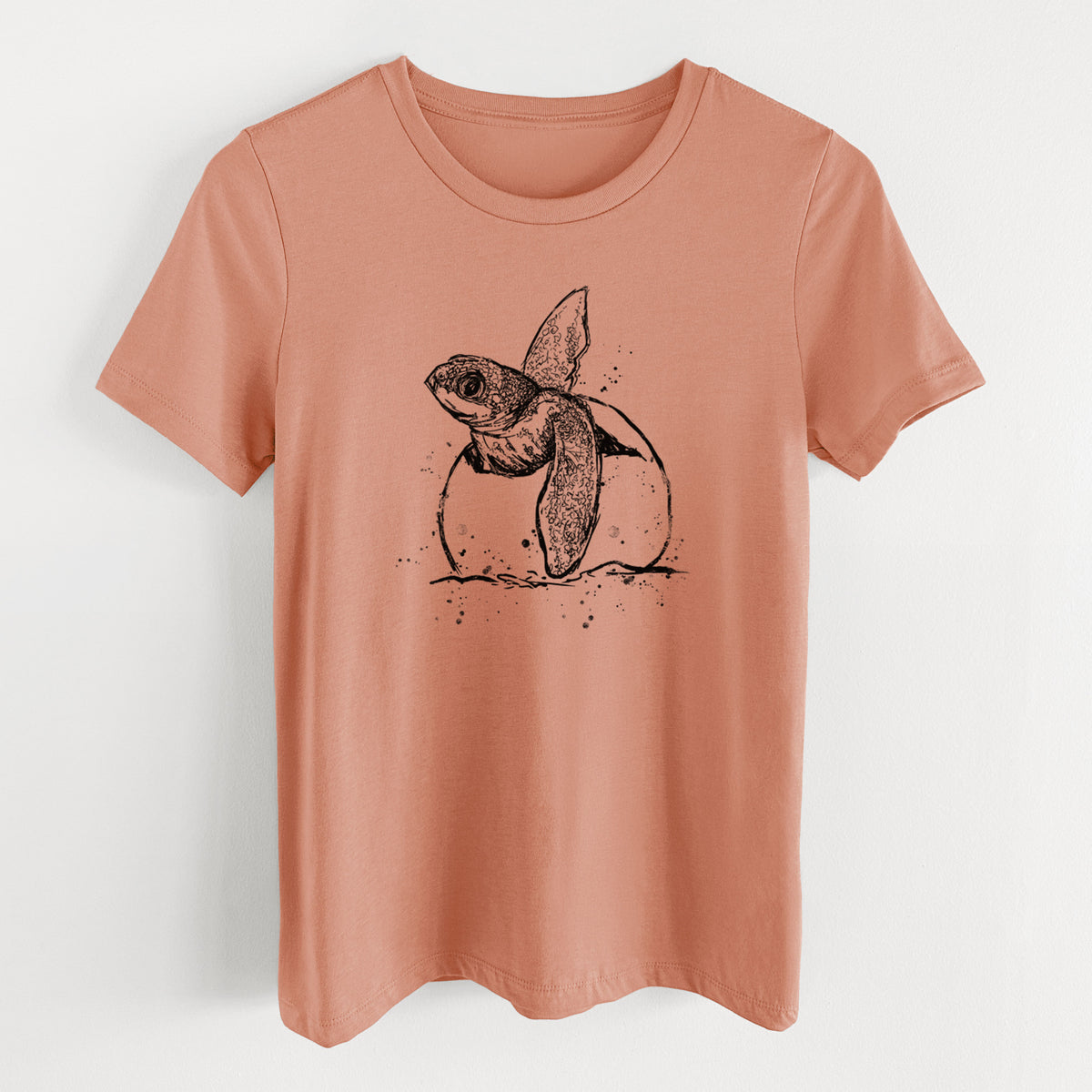Terracotta orange women's relaxed fit cotton t-shirt laid flat, printed with a black ink illustration of a leatherback sea turtle hatchling emerging from its egg.