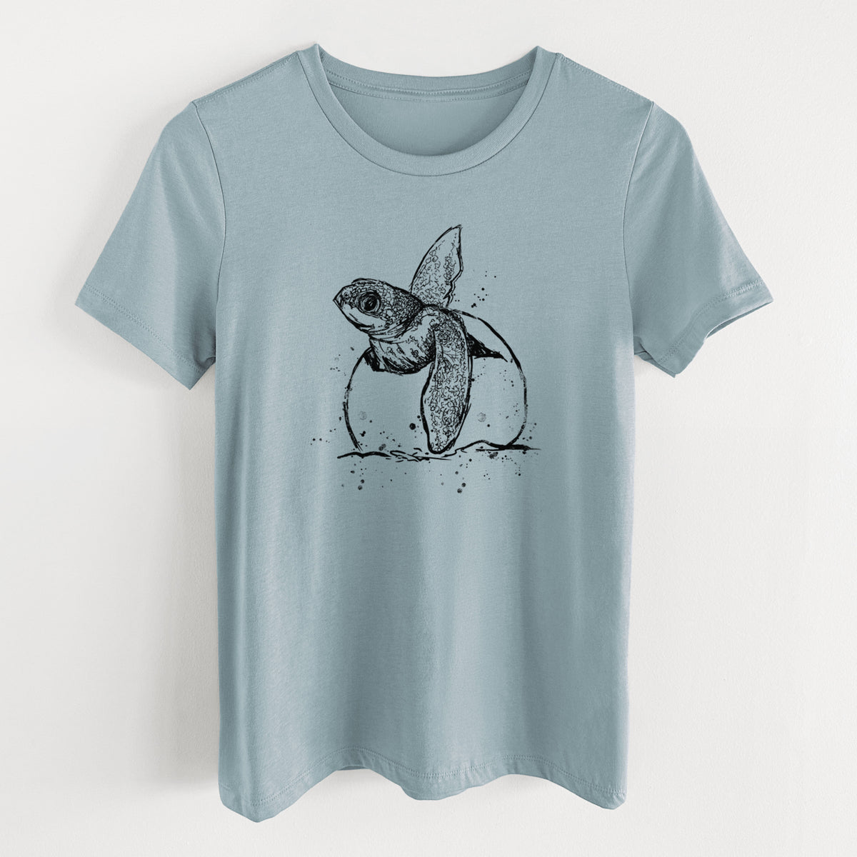Vintage denim women's relaxed fit cotton t-shirt laid flat, printed with a black ink illustration of a leatherback sea turtle hatchling emerging from its egg.