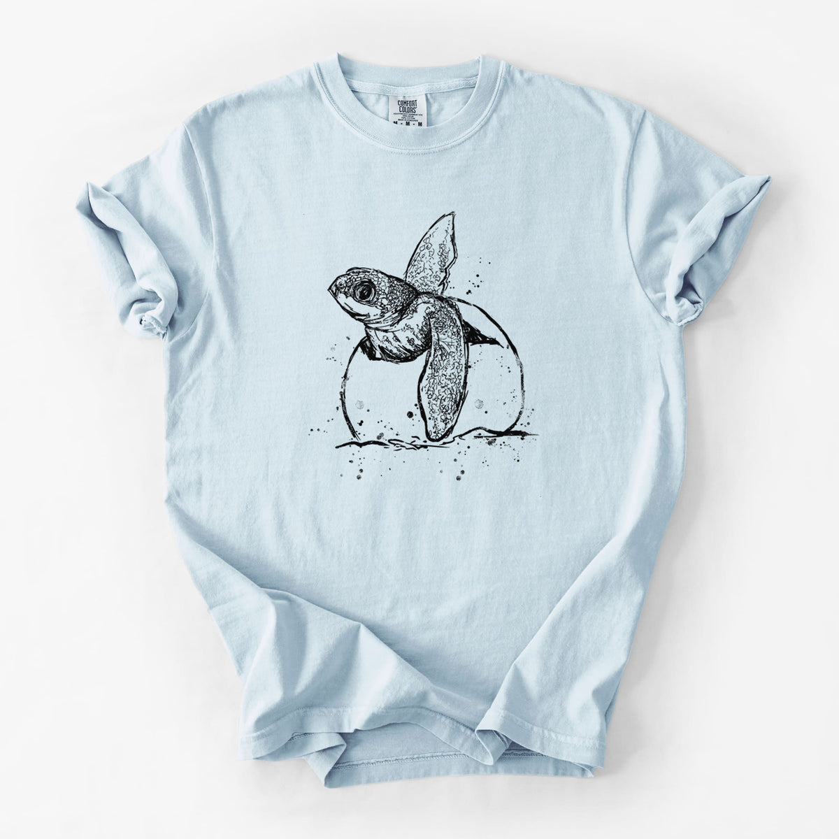 Chambray blue Comfort Colors t-shirt laid flat, printed with a black ink illustration of a leatherback sea turtle hatchling emerging from its egg.