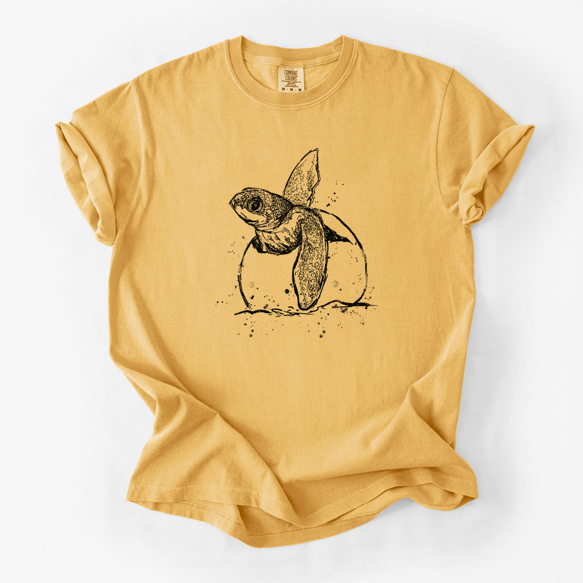 Golden wheat yellow Comfort Colors t-shirt laid flat, printed with a black ink illustration of a leatherback sea turtle hatchling emerging from its egg.