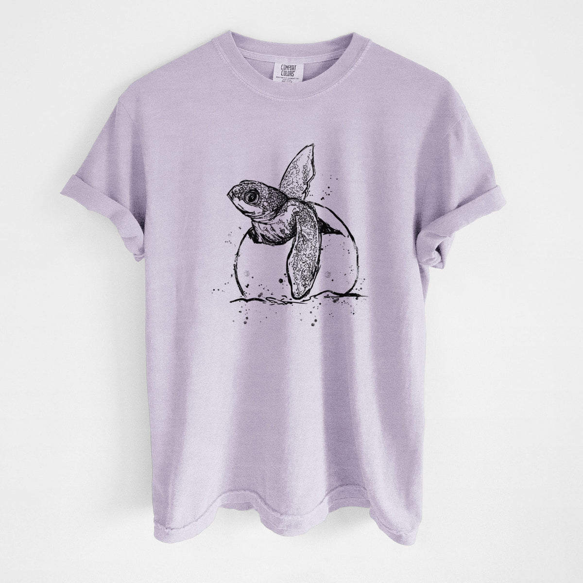 Orchid purple Comfort Colors t-shirt laid flat, printed with a black ink illustration of a leatherback sea turtle hatchling emerging from its egg.
