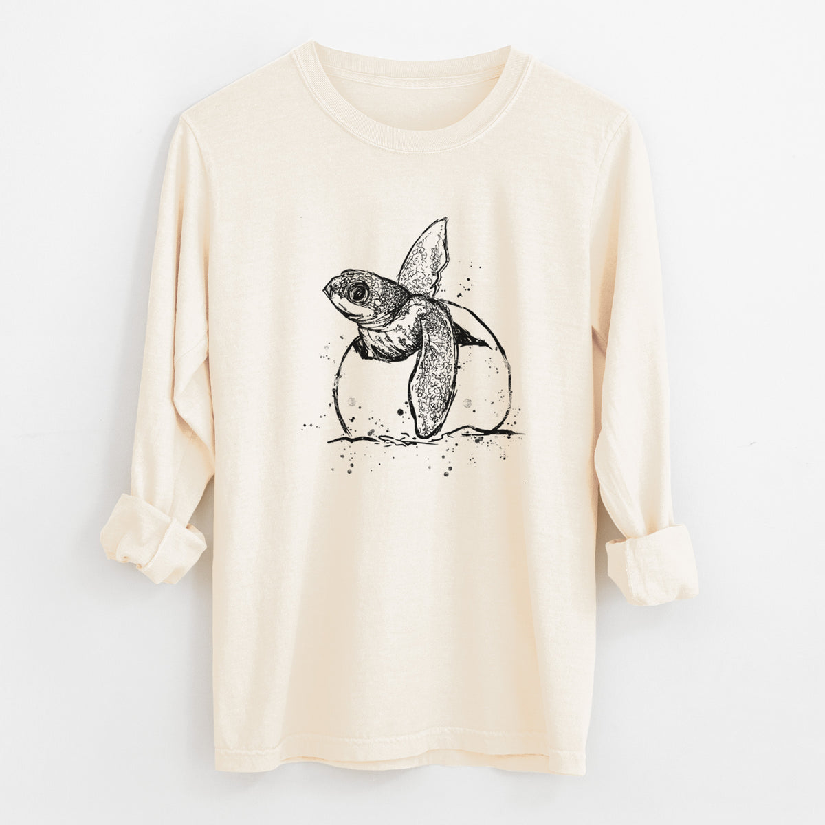 Ivory Comfort Colors long sleeve shirt laid flat with the cuffs rolled, printed with a black ink illustration of a leatherback sea turtle hatchling emerging from its egg.