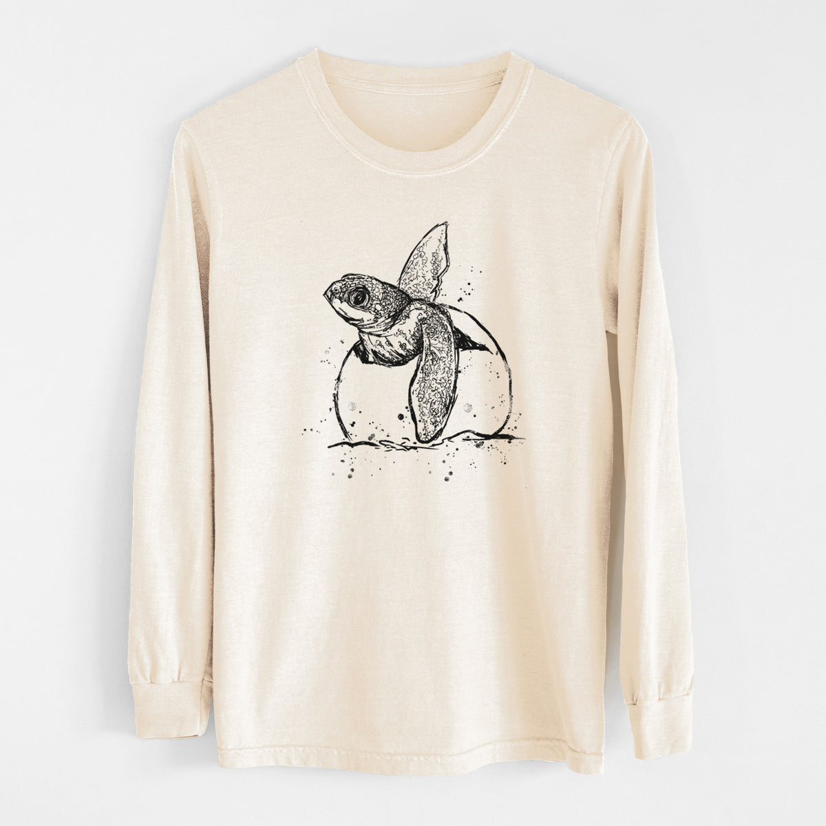Ivory Comfort Colors long sleeve shirt laid flat, printed with a black ink illustration of a leatherback sea turtle hatchling emerging from its egg.