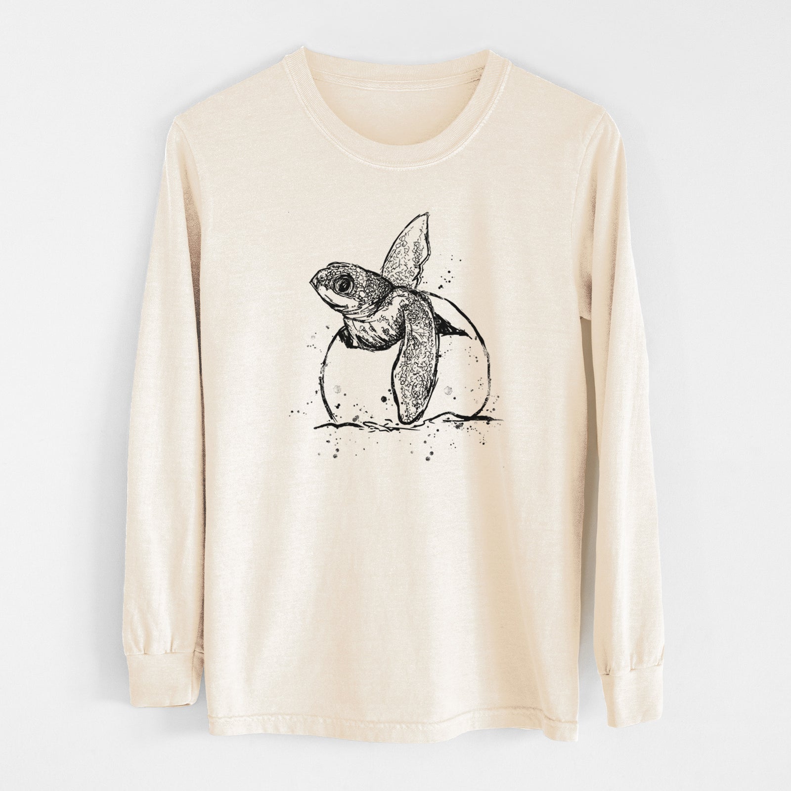 Ivory Comfort Colors long sleeve shirt laid flat, printed with a black ink illustration of a leatherback sea turtle hatchling emerging from its egg.