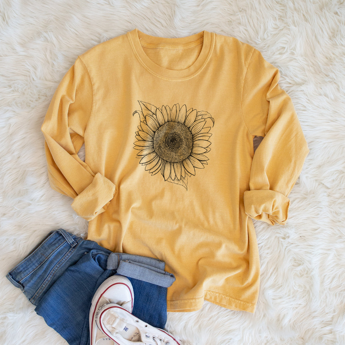 Golden wheat yellow Comfort Colors long sleeve shirt printed with a detailed black ink line drawing of a Lemon Queen sunflower in bloom, shown in a lifestyle photo.