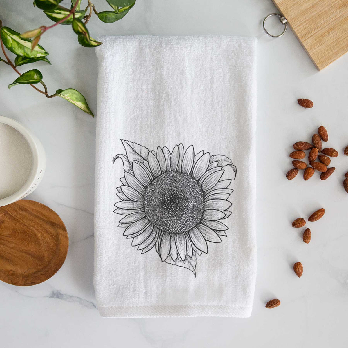 White hand towel printed with a detailed black ink line drawing of a Lemon Queen sunflower in bloom.