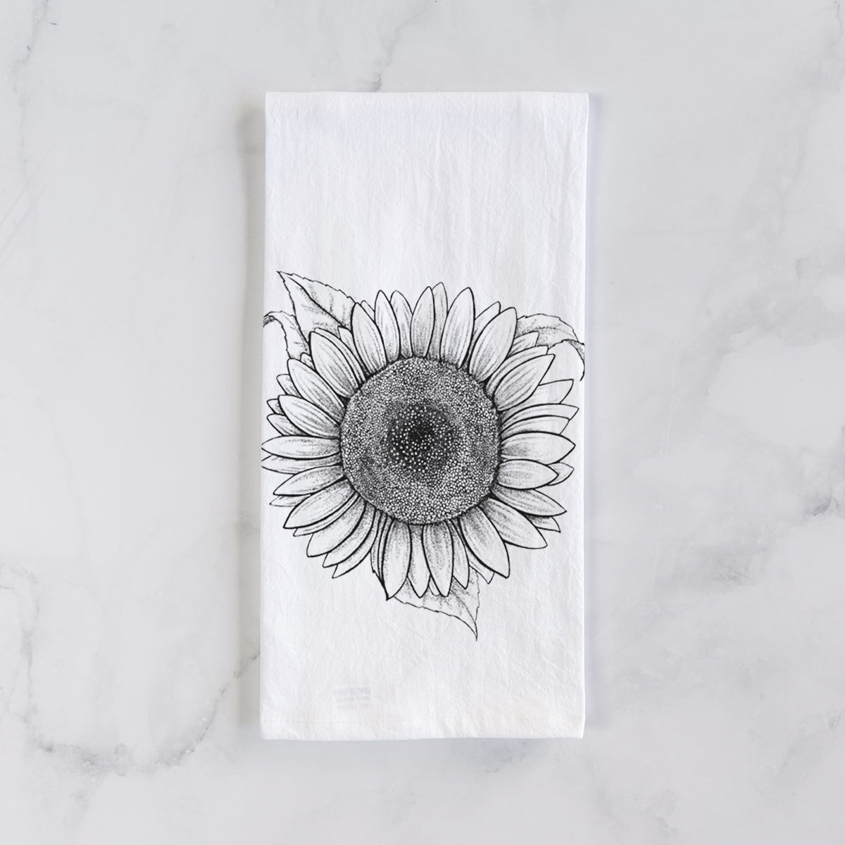 White cotton tea towel laid flat on marble, printed with a detailed black ink line drawing of a Lemon Queen sunflower in bloom.