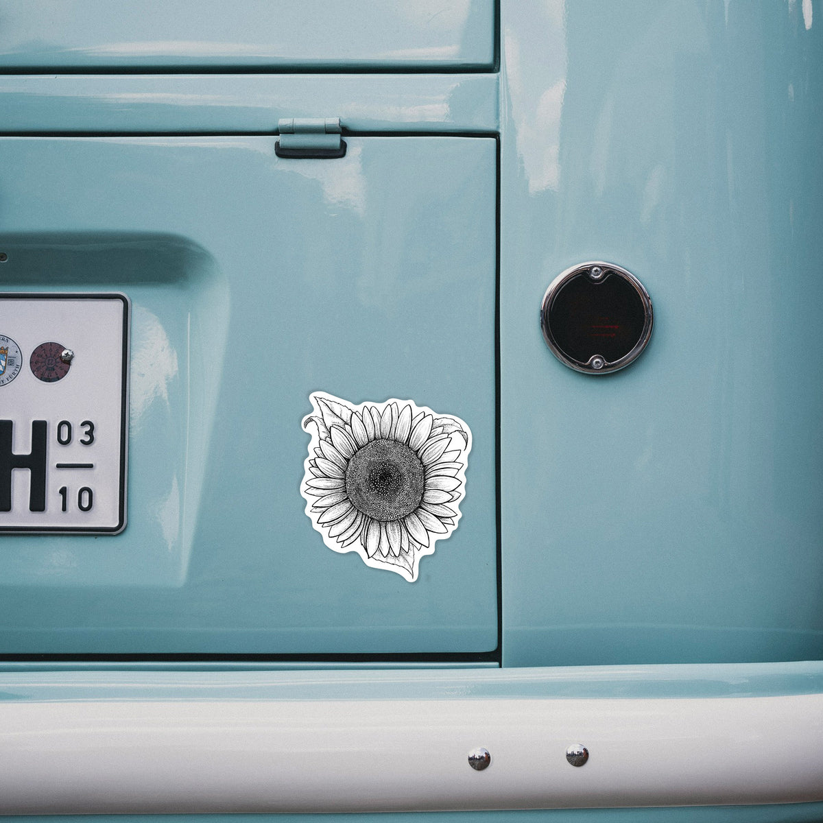 4 inch vinyl decal of a detailed black ink line drawing of a Lemon Queen sunflower in bloom on the back of a van.