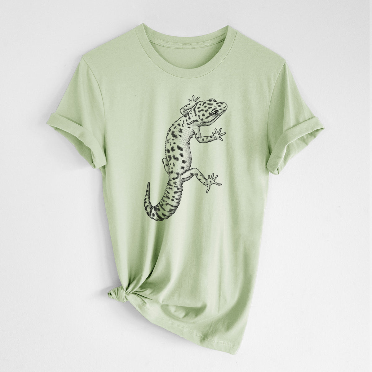 Spring green lightweight cotton t-shirt laid flat with the sleeves rolled, printed with a detailed black ink illustration of a spotted leopard gecko climbing.