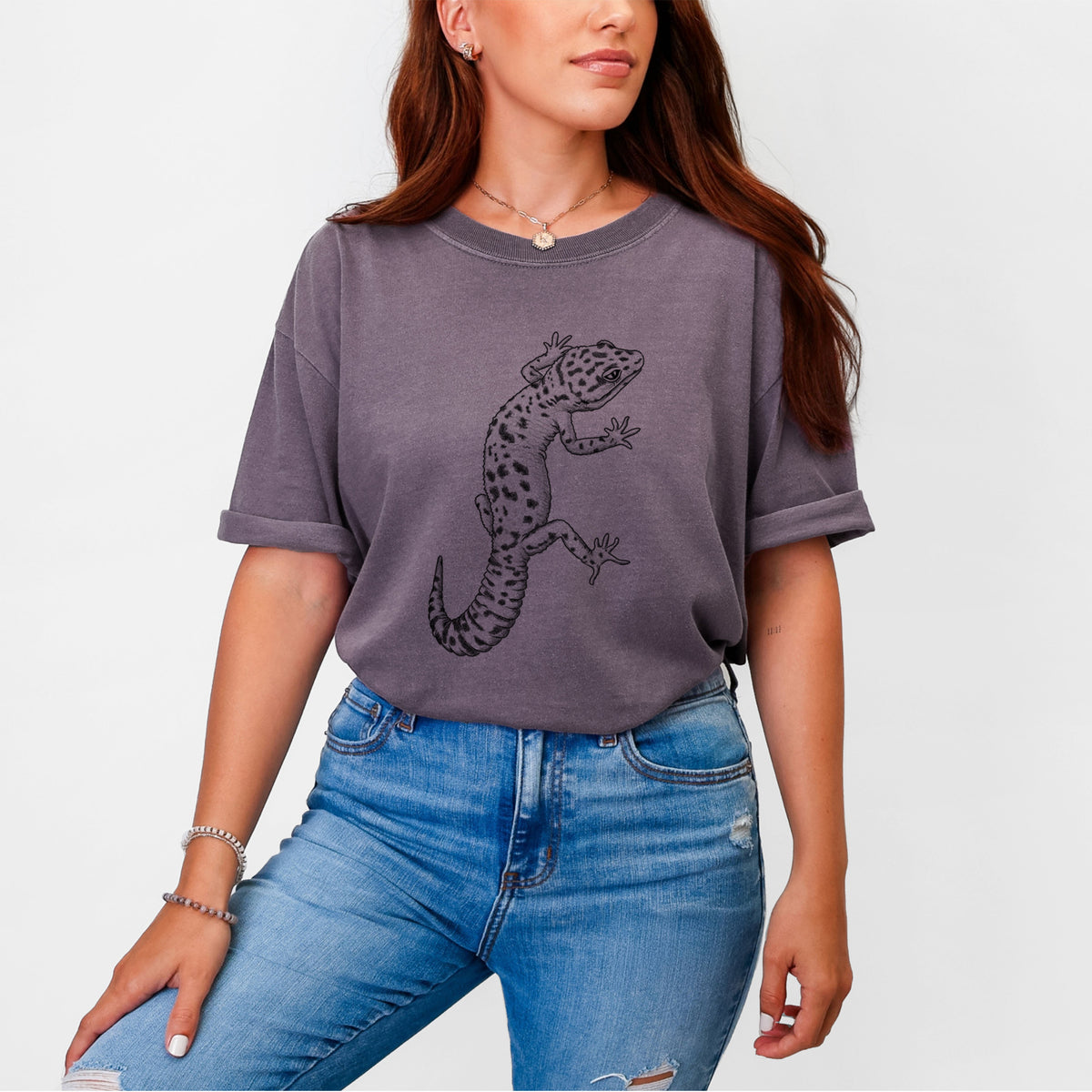 Woman wearing a Comfort Colors t-shirt printed with a detailed black ink illustration of a spotted leopard gecko climbing.