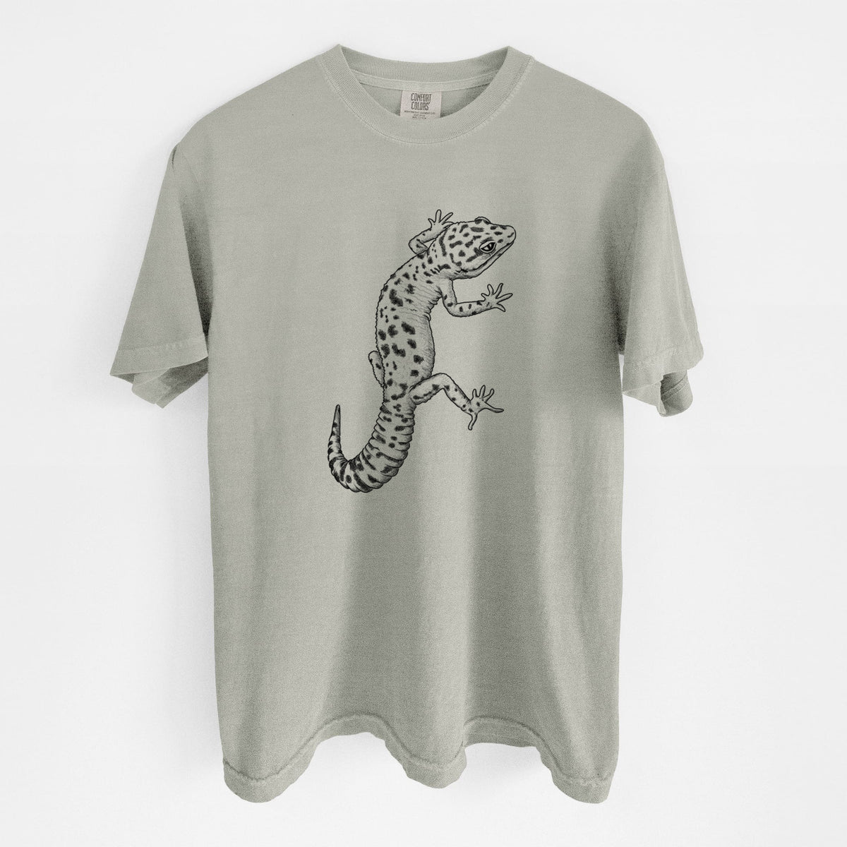 Sandstone beige Comfort Colors t-shirt laid flat, printed with a detailed black ink illustration of a spotted leopard gecko climbing.
