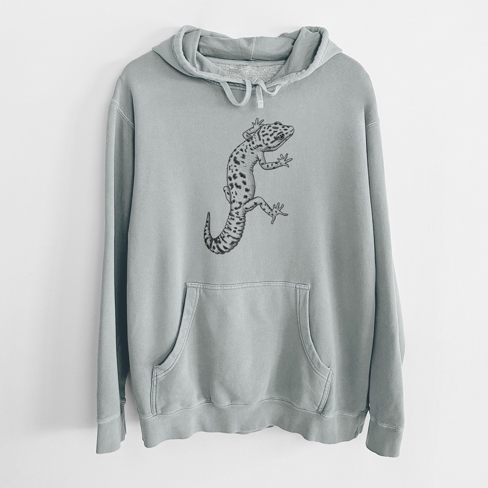 Sage green pigment dyed hoodie laid flat, printed with a detailed black ink illustration of a spotted leopard gecko climbing.