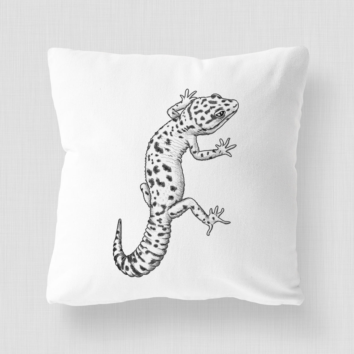 White pillow cover printed with a detailed black ink illustration of a spotted leopard gecko climbing.