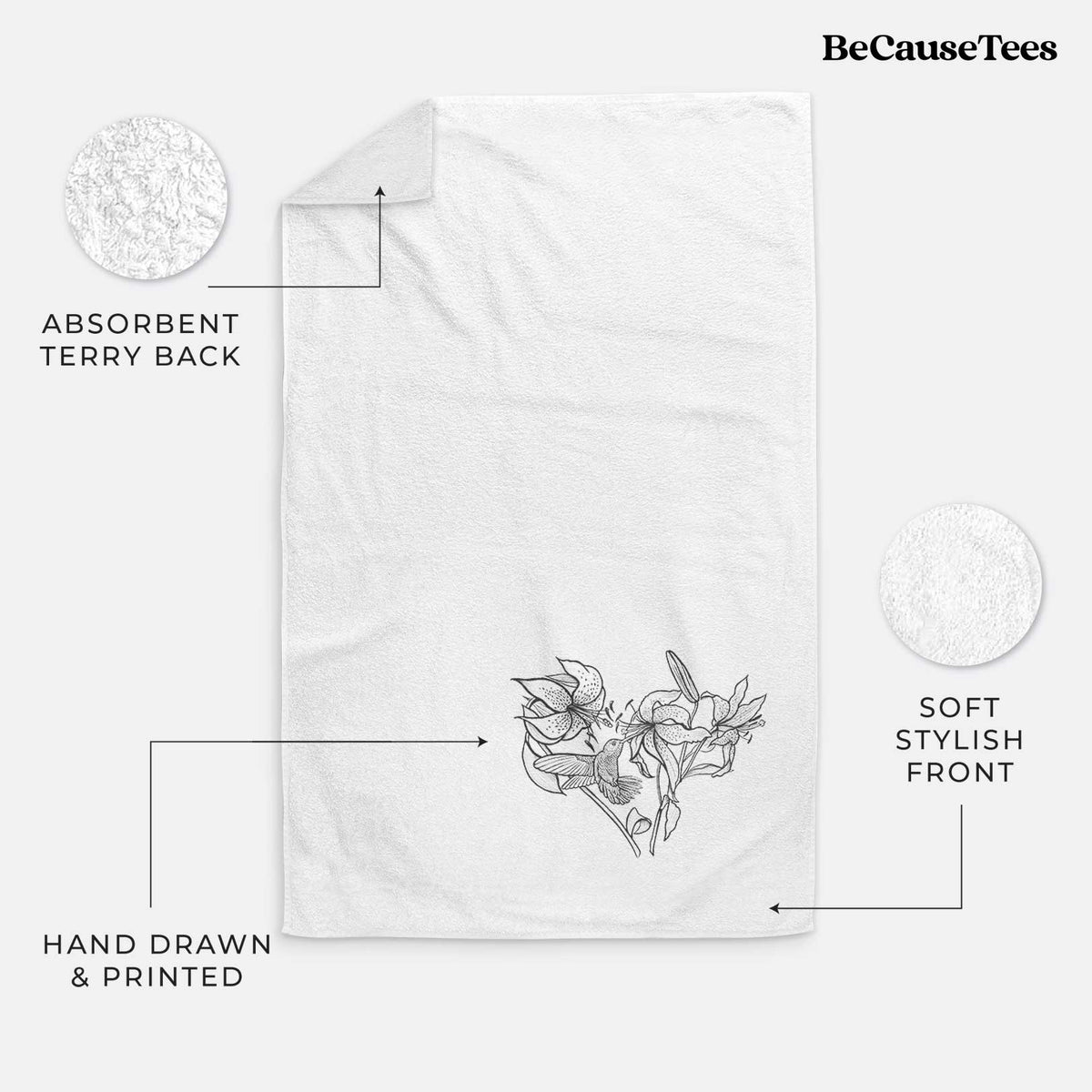 White hand towel printed with a black ink line drawing of lilies and a hummingbird arranged in a heart shape.