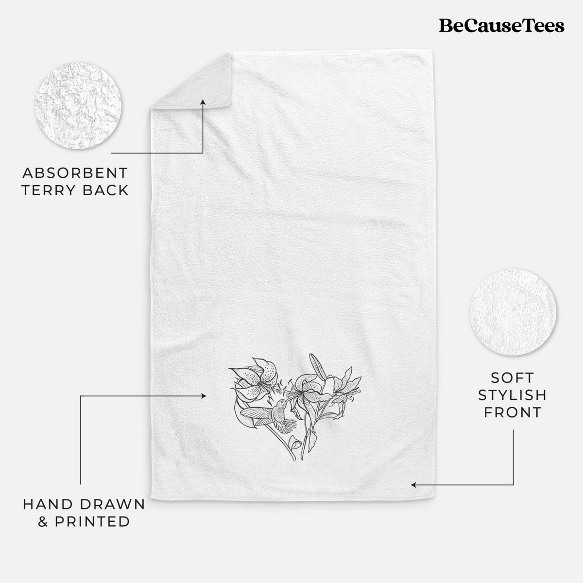 White hand towel printed with a black ink line drawing of lilies and a hummingbird arranged in a heart shape.