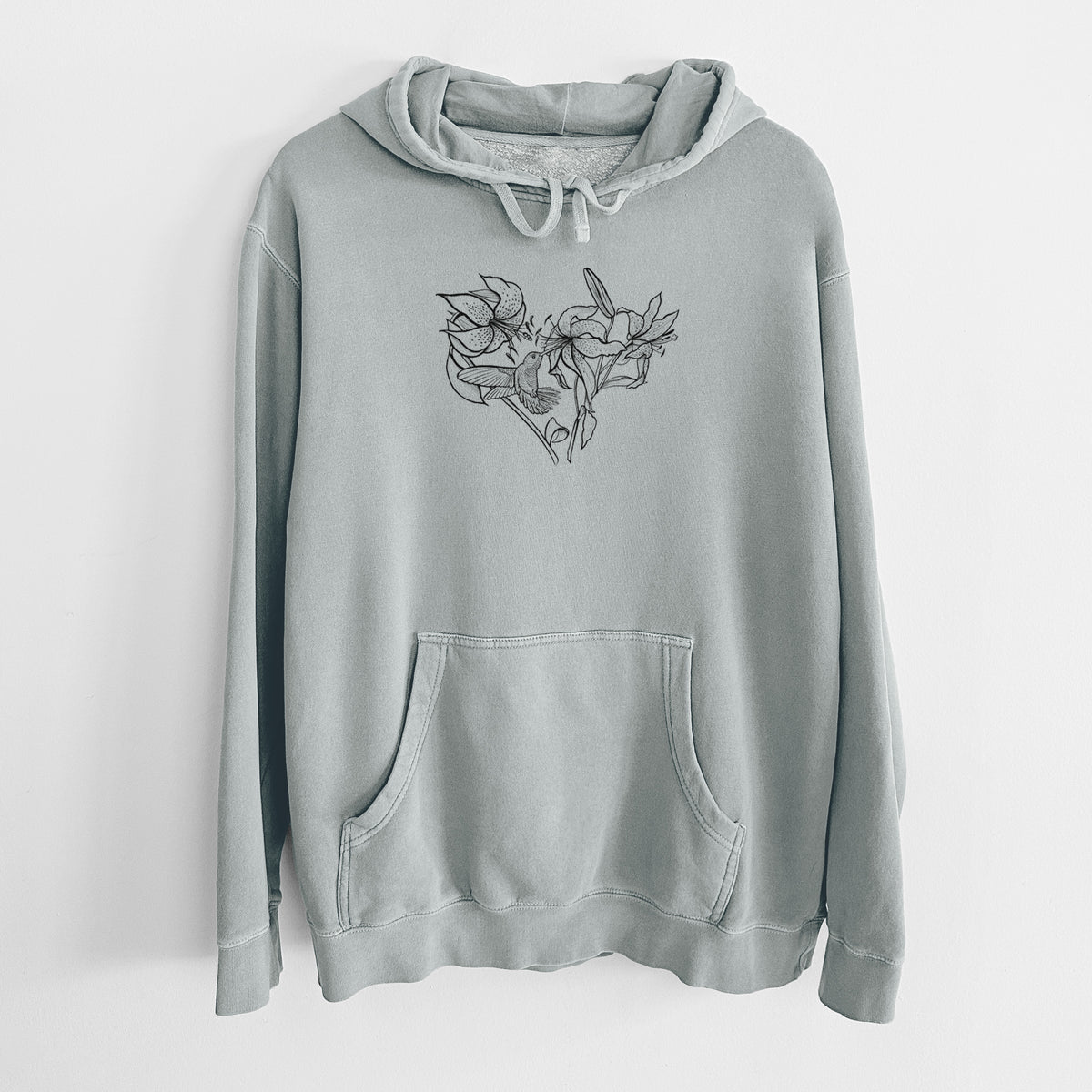 Sage green pigment dyed hoodie laid flat, printed with a black ink line drawing of lilies and a hummingbird arranged in a heart shape.