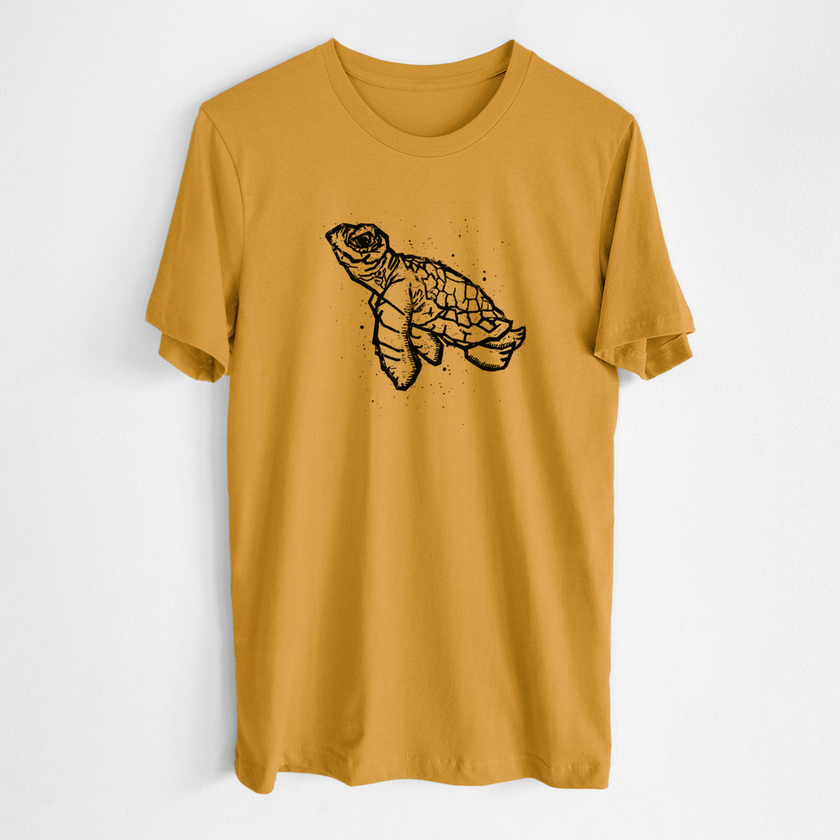 Honeycomb yellow lightweight cotton t-shirt laid flat, printed with a black linocut-style illustration of a baby sea turtle with a patterned shell and ink splatters.