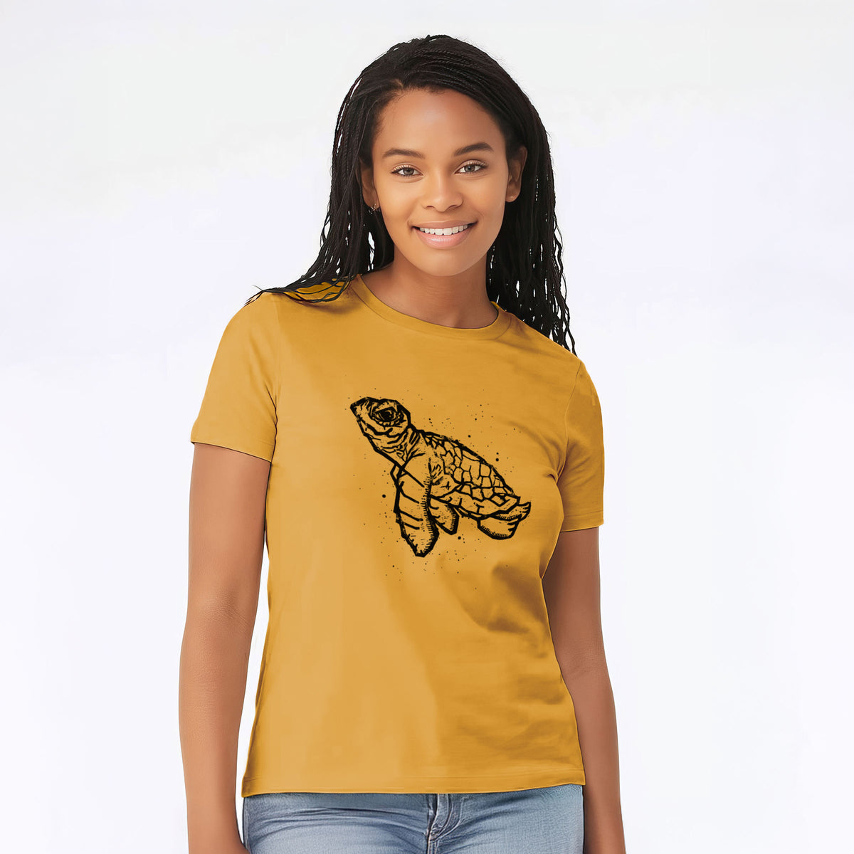 Woman wearing a mustard yellow women's relaxed fit cotton t-shirt printed with a black linocut-style illustration of a baby sea turtle with a patterned shell and ink splatters.