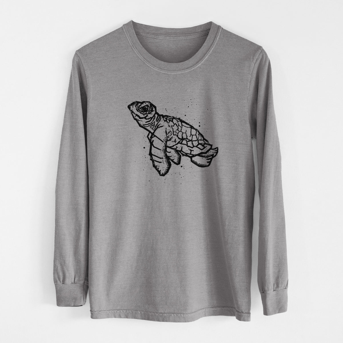 Grey Comfort Colors long sleeve shirt laid flat, printed with a black linocut-style illustration of a baby sea turtle with a patterned shell and ink splatters.
