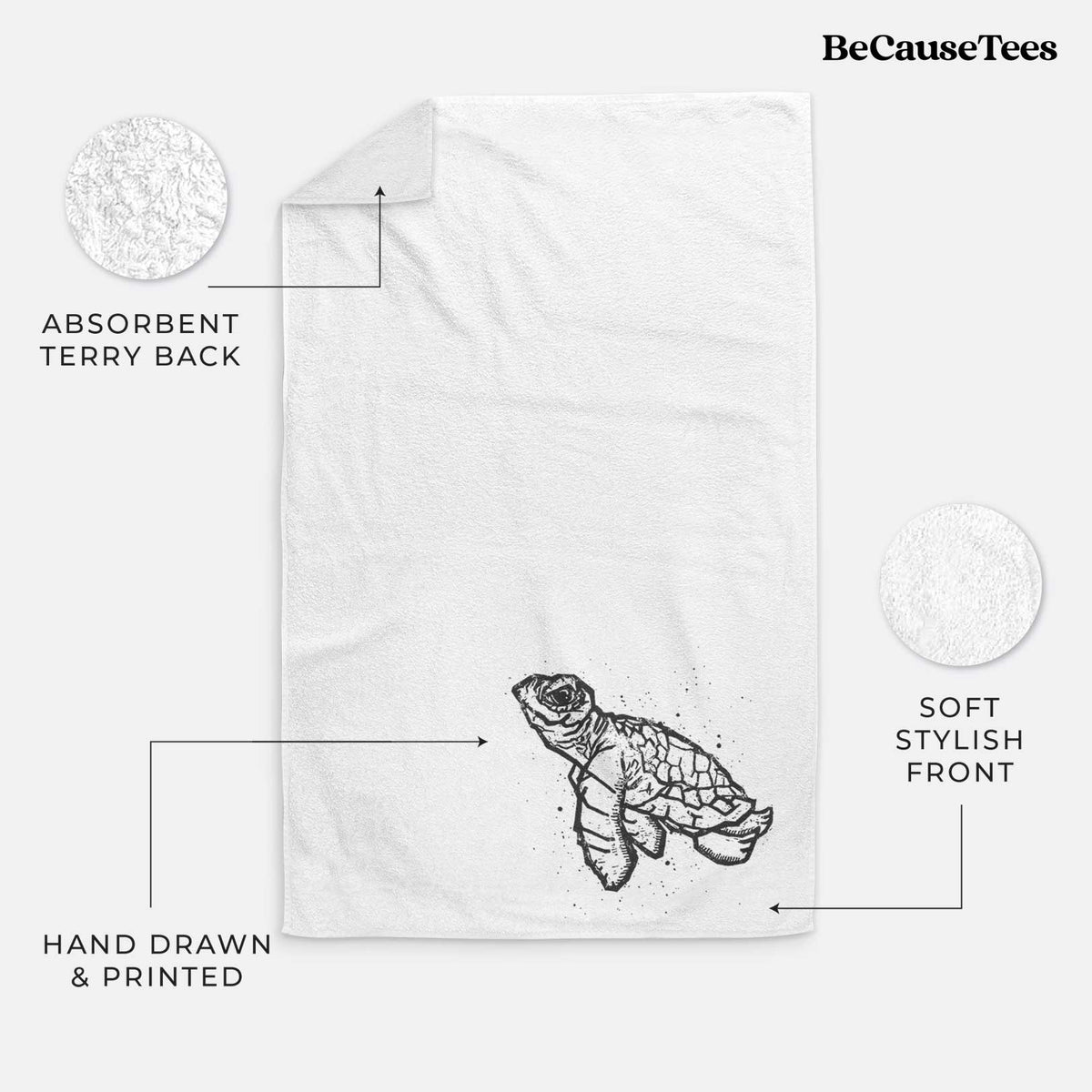 White hand towel printed with a black linocut-style illustration of a baby sea turtle with a patterned shell and ink splatters.
