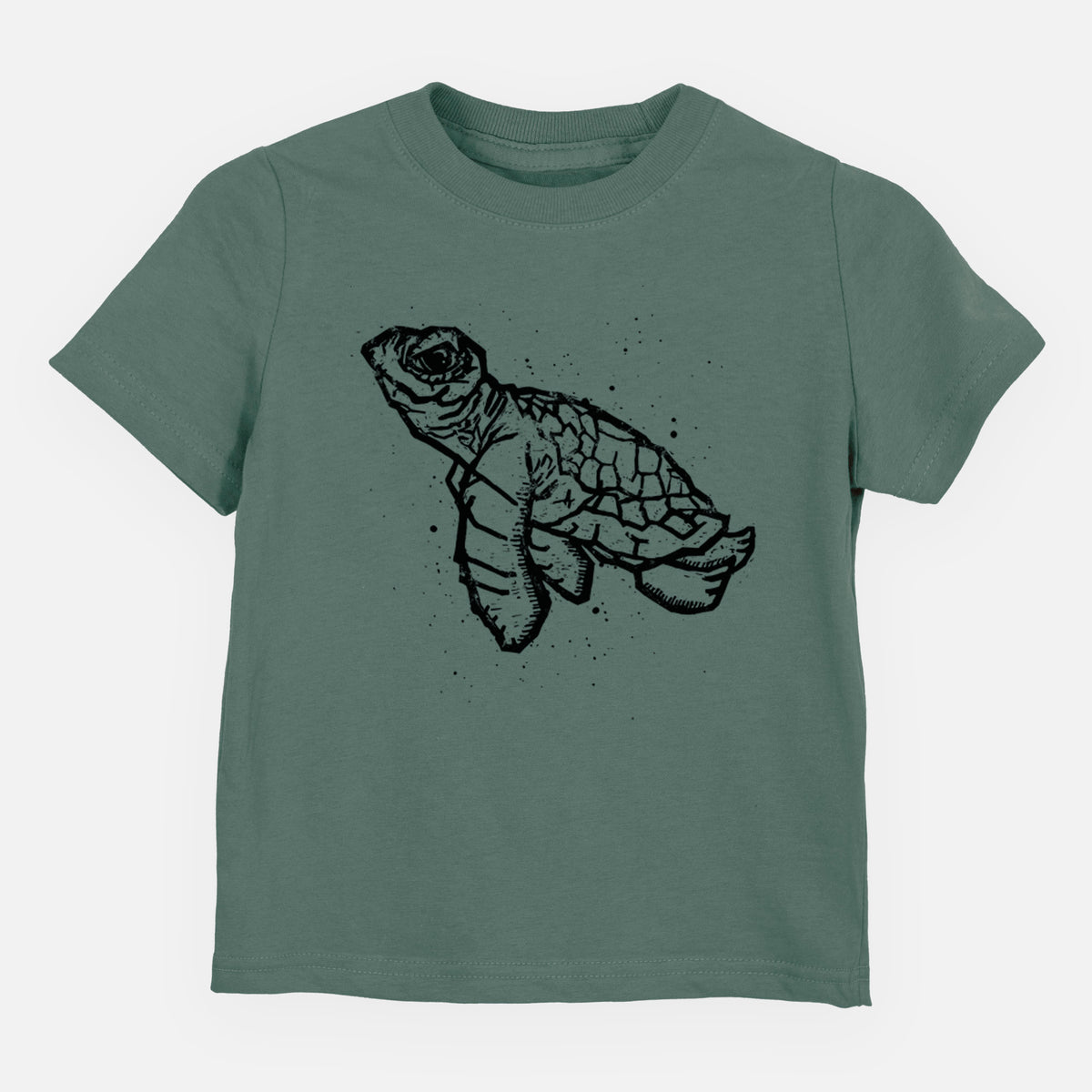 Basil green toddler t-shirt laid flat, printed with a black linocut-style illustration of a baby sea turtle with a patterned shell and ink splatters.