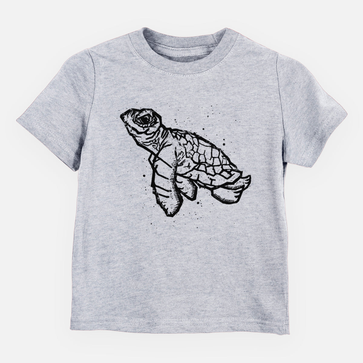 Heather grey toddler t-shirt laid flat, printed with a black linocut-style illustration of a baby sea turtle with a patterned shell and ink splatters.