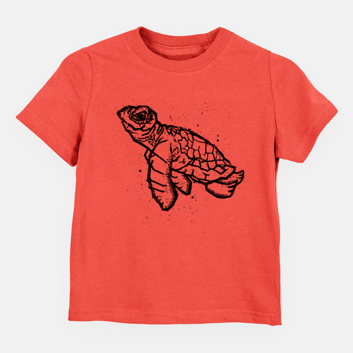Passionfruit pink toddler t-shirt laid flat, printed with a black linocut-style illustration of a baby sea turtle with a patterned shell and ink splatters.