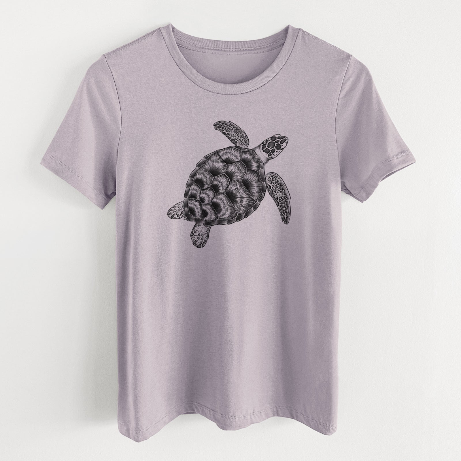 Light violet women's relaxed fit cotton t-shirt laid flat, printed with a detailed black ink illustration of a loggerhead sea turtle swimming, seen from above.