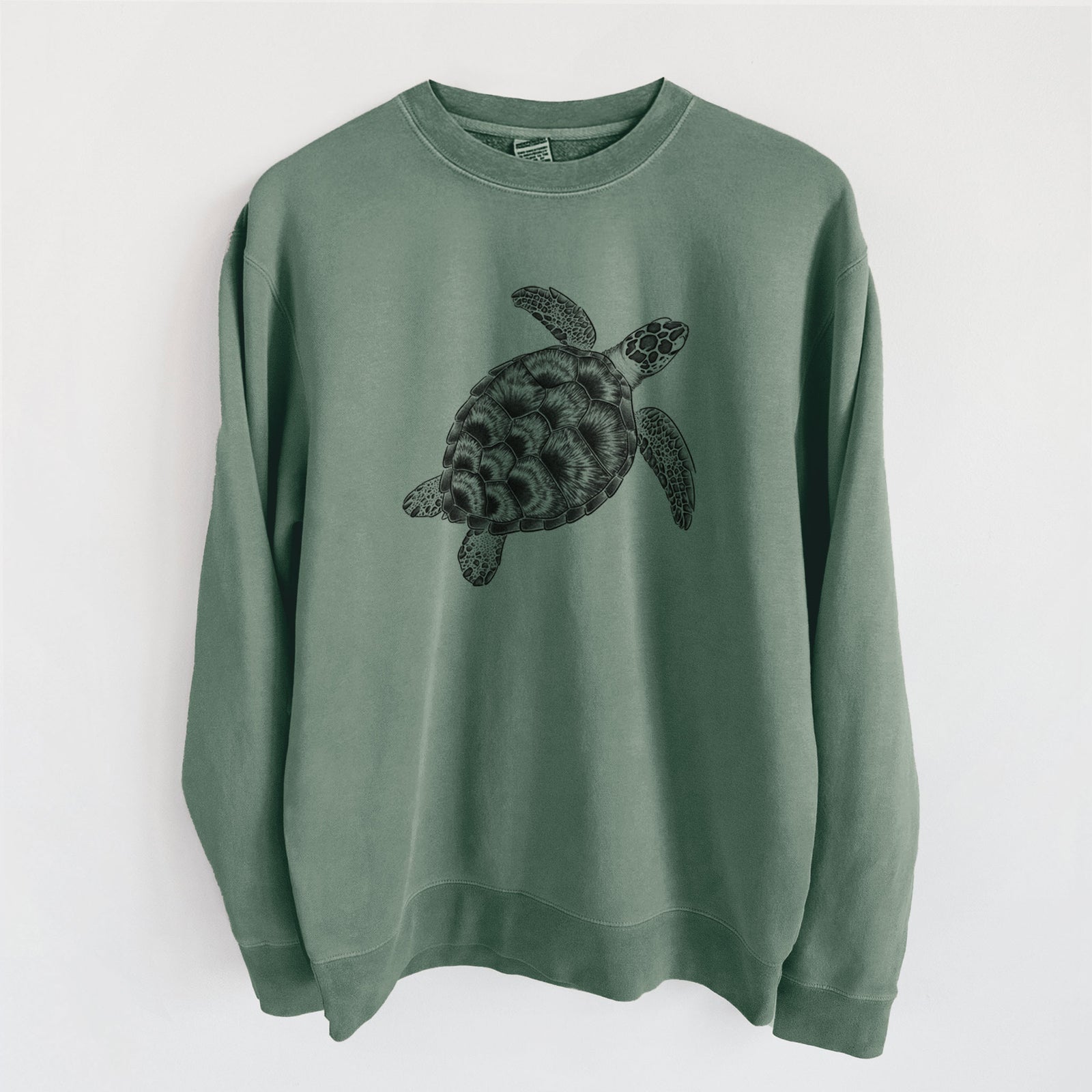 Alpine green pigment dyed crewneck sweatshirt laid flat, printed with a detailed black ink illustration of a loggerhead sea turtle swimming, seen from above.