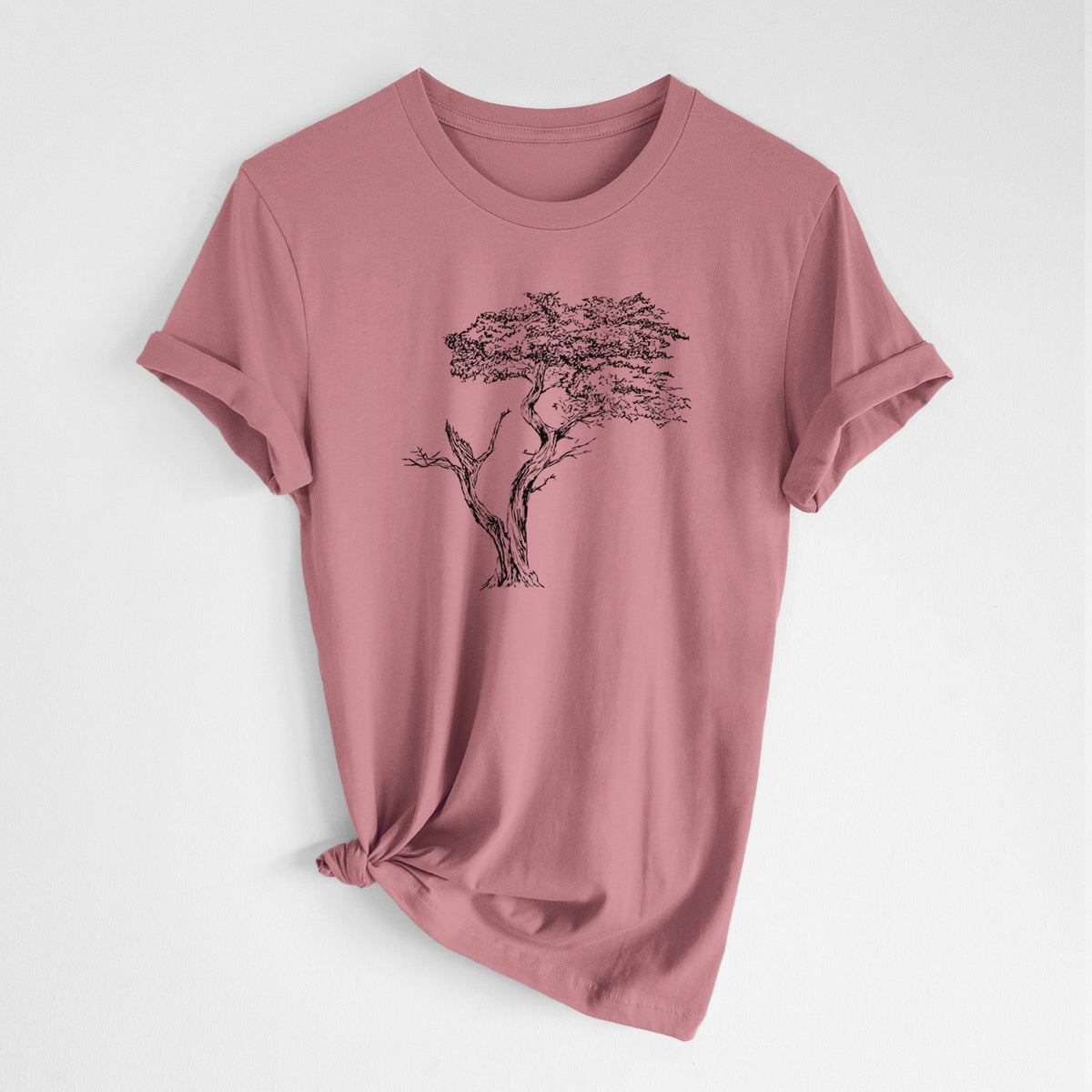 Mauve pink lightweight cotton t-shirt laid flat with the sleeves rolled, printed with a black ink illustration of the windswept Lone Cypress tree on a rocky outcrop.