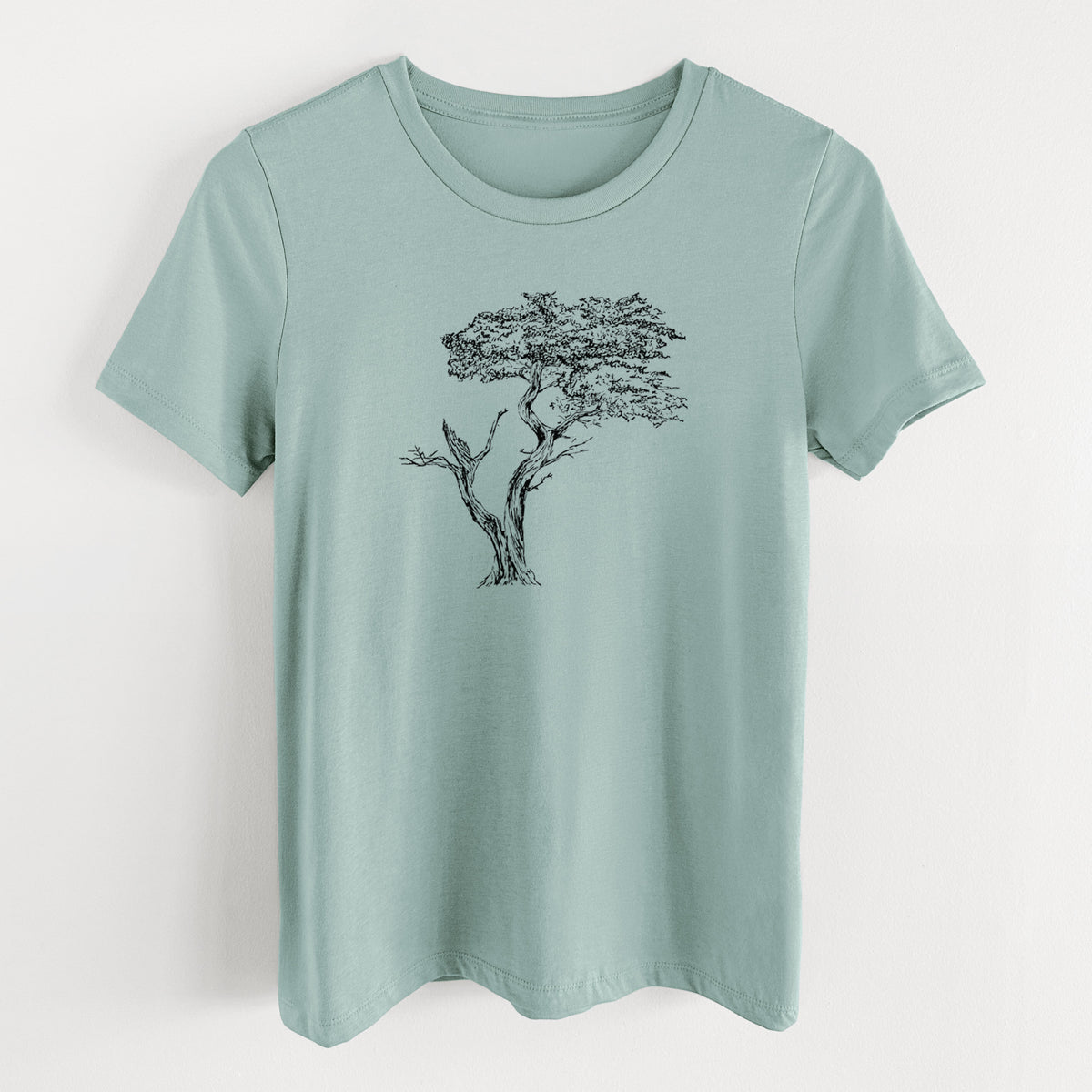 Dusty blue women's relaxed fit cotton t-shirt laid flat, printed with a black ink illustration of the windswept Lone Cypress tree on a rocky outcrop.