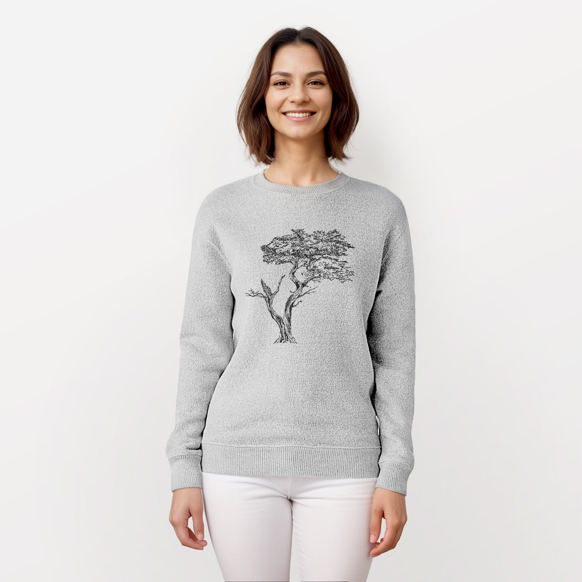 Woman wearing a knit sweatshirt printed with a black ink illustration of the windswept Lone Cypress tree on a rocky outcrop.
