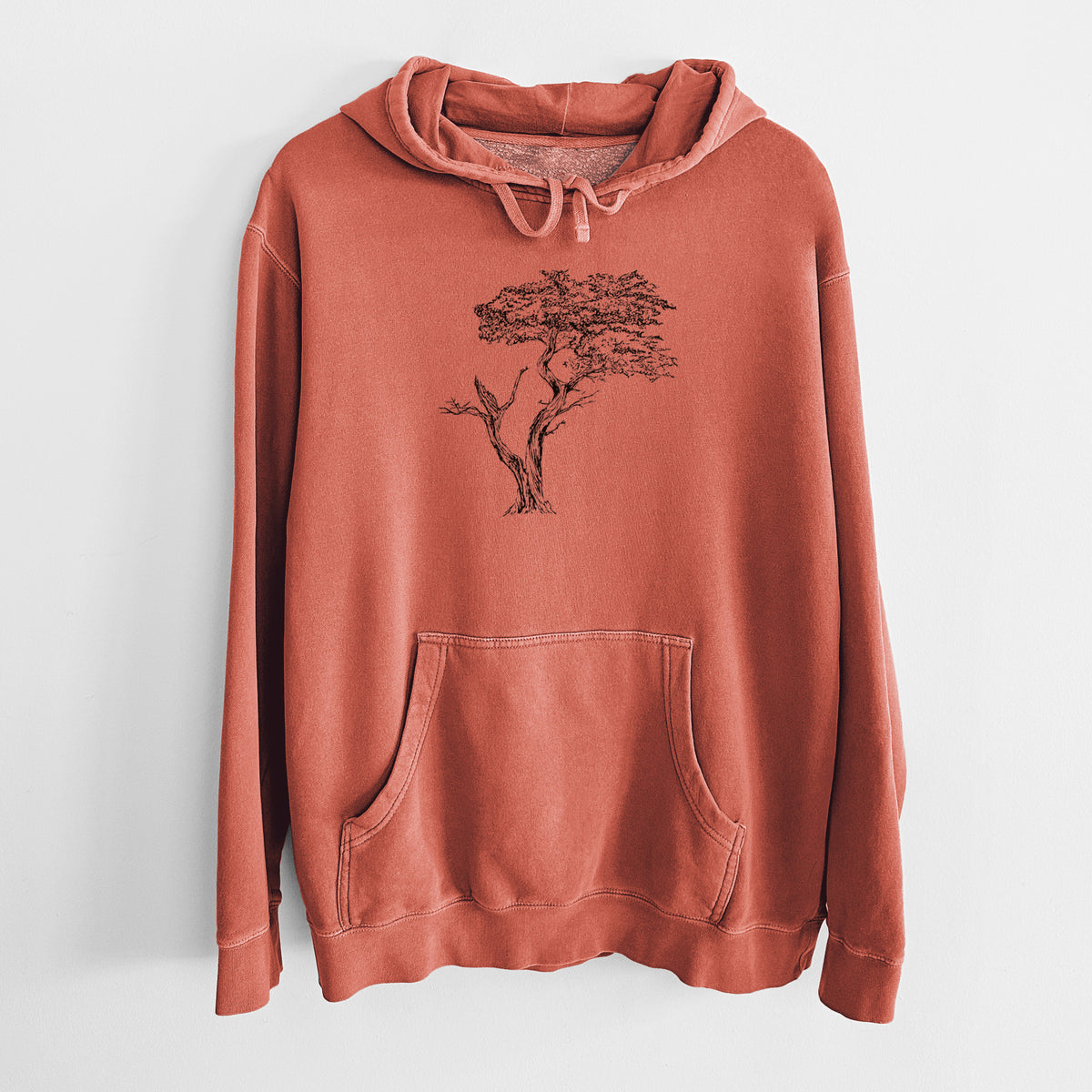 Amber orange pigment dyed hoodie laid flat, printed with a black ink illustration of the windswept Lone Cypress tree on a rocky outcrop.