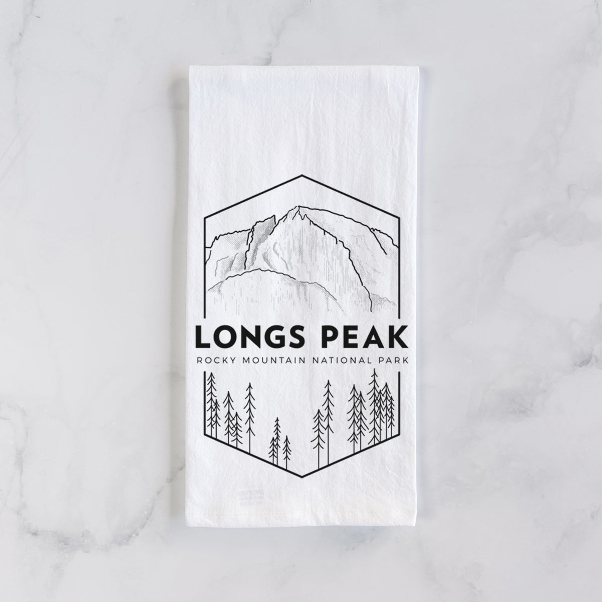 White cotton tea towel laid flat on marble, printed with a black line art badge of Longs Peak above a pine forest, with the words Longs Peak, Rocky Mountain National Park.