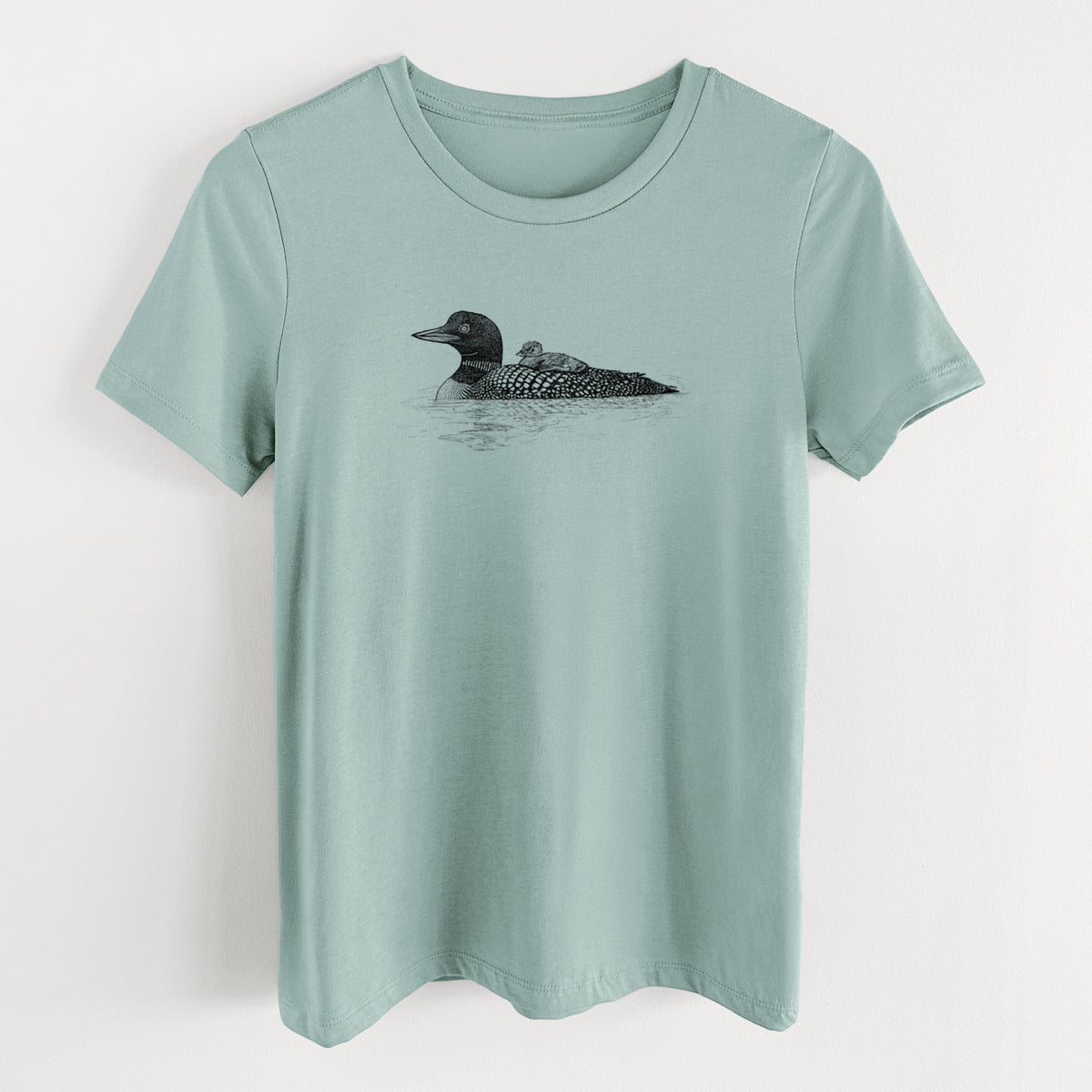Dusty blue women's relaxed fit cotton t-shirt laid flat, printed with a black ink sketch of a common loon floating on water with a chick riding on its back.