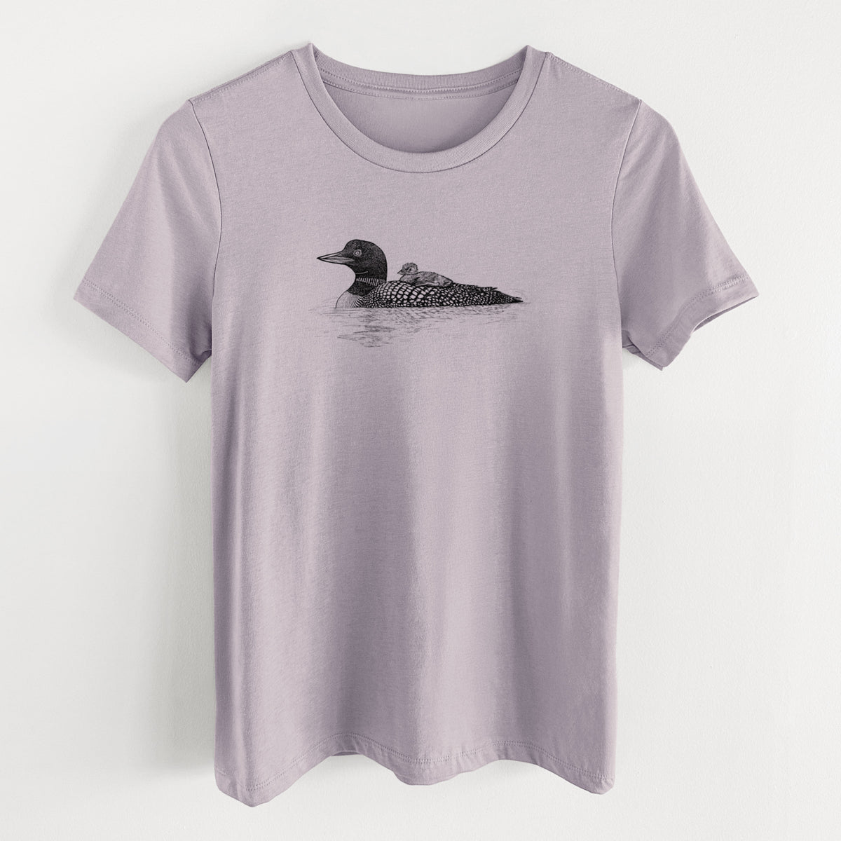 Light violet women's relaxed fit cotton t-shirt laid flat, printed with a black ink sketch of a common loon floating on water with a chick riding on its back.