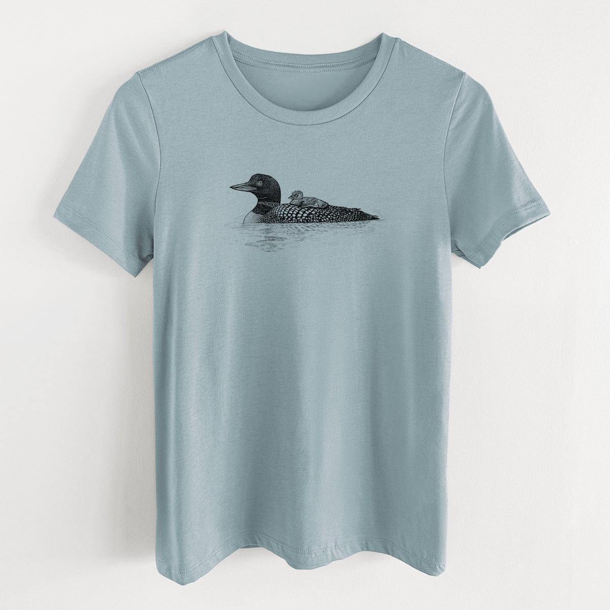 Vintage denim women's relaxed fit cotton t-shirt laid flat, printed with a black ink sketch of a common loon floating on water with a chick riding on its back.
