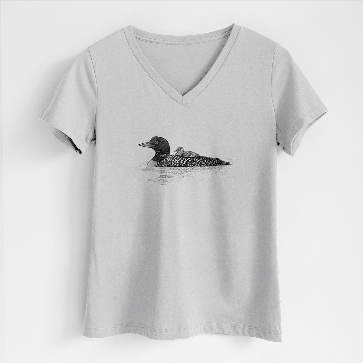 Lunar grey women's relaxed fit cotton V-neck t-shirt laid flat, printed with a black ink sketch of a common loon floating on water with a chick riding on its back.