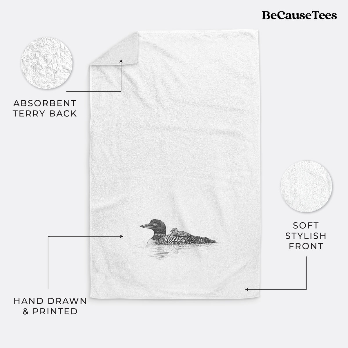 White hand towel printed with a black ink sketch of a common loon floating on water with a chick riding on its back.