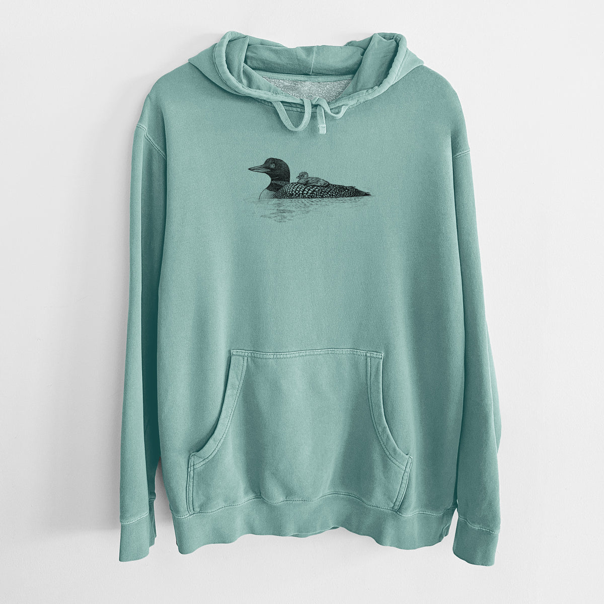 Mint green pigment dyed hoodie laid flat, printed with a black ink sketch of a common loon floating on water with a chick riding on its back.