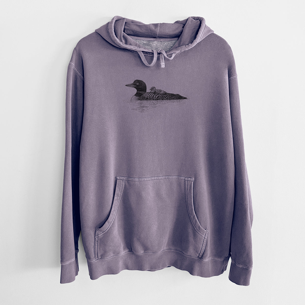 Plum purple pigment dyed hoodie laid flat, printed with a black ink sketch of a common loon floating on water with a chick riding on its back.