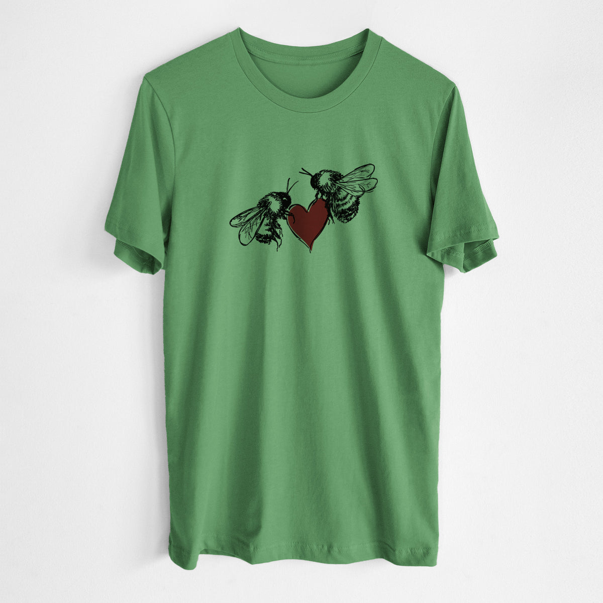 Leaf green lightweight cotton t-shirt laid flat, printed with a black ink illustration of two bees facing each other with a red heart between them.